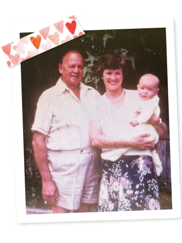 A scrapbook styled photo of Pam's parents holding her as a baby